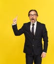 Pointing finger up, i have an idea middle aged businessman excited looking at camera isolated on yellow background Royalty Free Stock Photo