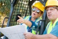 Pointing Male and Female Workers With Technical Blueprints Talking Royalty Free Stock Photo