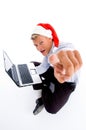 Pointing man with christmas hat and laptop