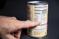 Pointing at the Nutritional facts on a grocery Can of food.