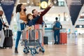 Pointing, travel and interracial family at the airport looking at a departure time for a flight. Happy, trip and parents