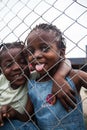 POINTNOIRE/CONGO - 18MAY2013 - African children behind metal grille smiling.
