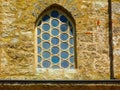 pointy arched Moorish style wood window in stone wall. old turkish built Mosque in Pecs, Hungary Royalty Free Stock Photo