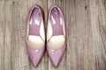 Pointy patent pumps in old pink color on wooden floor