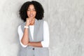 Poised African-American businesswoman in a sleek gray suit stands contemplatively