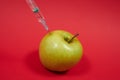 Poison enters the green apple with a syringe. Royalty Free Stock Photo