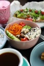Poke bowl with healthy and natural ingredients served in a restaurant. Exotic lunch meal prepared with hummus dip, sliced avocado