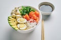 poke bowl with salmon, avocado rice, Chuka Salad, quail eggs sprinkled with white and black sesame with chopsticks,soy sauce