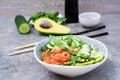 Poke bowl with salmon, cucumber, avocado, arugula and seasame seeds Royalty Free Stock Photo