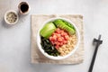 Poke bowl with salmon, quinoa, wakame seaweed, avocado and cucumber on gray background. Royalty Free Stock Photo