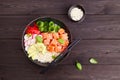 Poke bowl with salmon, rice, avocado, cucumber, radish, pepper, sesame seeds Royalty Free Stock Photo