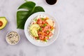 Poke bowl with salmon or tuna, rice, avocado, sesame seeds, micro greens and persimmon. Royalty Free Stock Photo