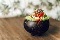 Poke bowl with tuna, avocado, vegetables and sesame on pattern background.