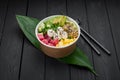 Poke bowl with tuna, rice, avocado, cucumber, cream cheese and mango on dark background Royalty Free Stock Photo