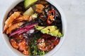 Poke in a gray bowl on a light background. Hawaiian cuisine. Soft focus.