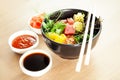 Poke salad with tuna in a bowl. Ingredients fresh tuna, cherry tomatoes, marinated seaweed, rice, takuan, Ponzu sauce