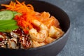 Poke with shrimps and salmon in a deep cup