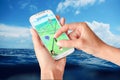 Pokemon Go on hand held white smartphone on the sea