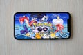 Pokemon GO mobile iOS game on iPhone 15 smartphone screen on wooden table during mobile gameplay Royalty Free Stock Photo