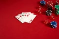 Poker cards and gambling chips on red background