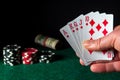 Poker cards with royal flush combination in the game. Close-up of a gambler hand is holding playing cards in poker club. Chips on Royalty Free Stock Photo