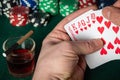 Poker cards with a winning combination. Close up of a gambler hand is holding playing cards in poker club