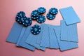 Poker chips and cards on a pink background. The game of poker. Chip dealer
