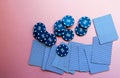 Poker chips and cards on a pink background. The game of poker. Chip dealer.