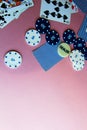 Poker chips and cards on a pink background. The game of poker. Chip dealer