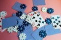 Poker chips and cards on a pink background. The game of poker. Gambling.