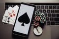 Poker chips, cards and smartphone on a laptop keyboard. Poker online concept Royalty Free Stock Photo