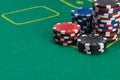 Poker chips are in the corner against a green playing field