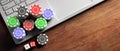 Poker chips and dice on computer laptop, wooden background, top view, copy space. 3d illustration