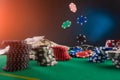 Poker chips falling on a table in a casino against a background of money. Casino game, poker and online business Royalty Free Stock Photo