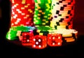 Poker Chips with Red Dice in forground close up on black backgrund, color fantasy, Vegas style Royalty Free Stock Photo