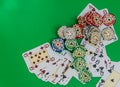 Poker chips stack and playing cards on green table