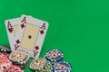 Poker chips stack and playing cards - two aces on green table Royalty Free Stock Photo