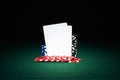 Poker chips on table with pair of blank cards