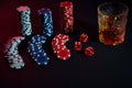 Poker chips and wine glass of cognac on dark table. Gambling Royalty Free Stock Photo