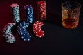 Poker chips and wine glass of cognac on dark table. Gambling Royalty Free Stock Photo