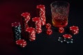 Poker chips and wine glass of cognac on dark table. Gambling Royalty Free Stock Photo