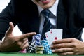 The poker gambler use finger pointing to a pair of aces and hold