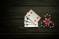 Poker game with four of kind combination. Chips and cards on the black vintage table. Successful and maximum win. Copy space