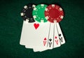 Poker game with four of kind combination. Chips and cards on the green table. Successful and maximum win