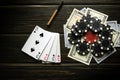 A poker game with a winning combination of four of a kind or quads. Cards with chips and money on a black table in a poker club