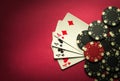 Poker game with a winning combination of four of a kind or quads. Cards with chips on a red table in a poker club