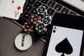 Poker play online. Poker chips, playing cards and smartphone on keyboard Royalty Free Stock Photo
