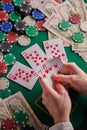 A poker player in a casino, a combination of straight flush cards, a lot of money and chips. Vertical frame Royalty Free Stock Photo