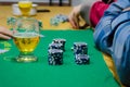 Poker chips with playing cards on a green table