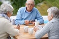Poker, playing cards and senior group in retirement, outdoor and relaxed in garden, backyard and terrace. Elderly people Royalty Free Stock Photo